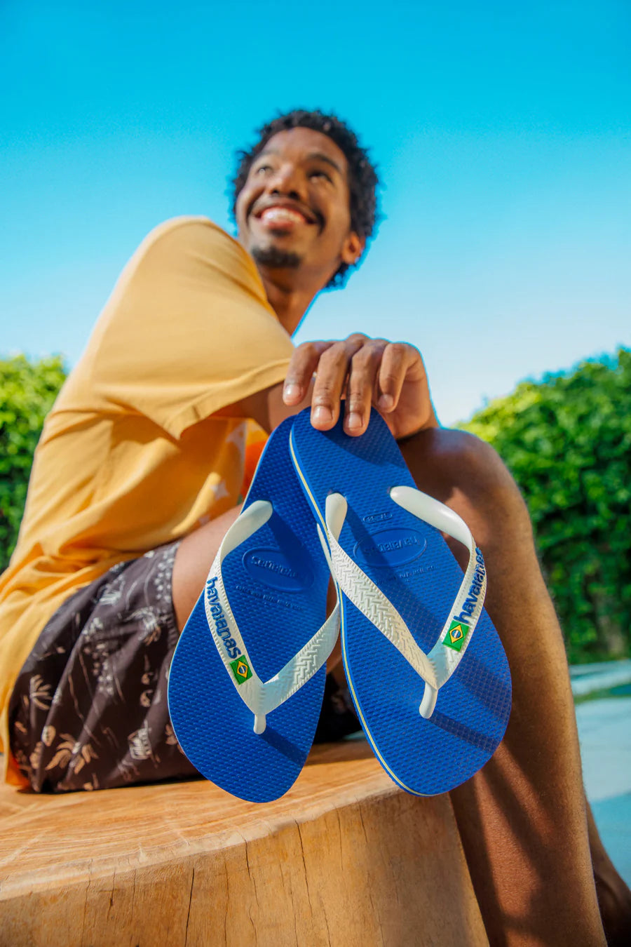 Infradito Havaianas blu e bianche indossate in un contesto estivo a bordo piscina, scarpe comode e impermeabili per mare e tempo libero.